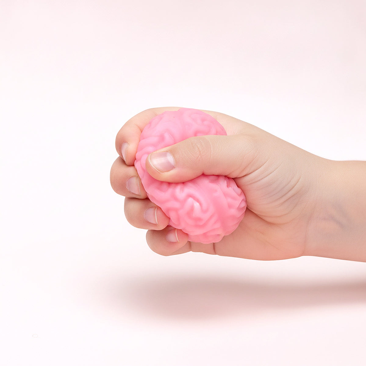 Squishy Cerveau de zombie pressé dans une main d'enfant pour montrer sa taille