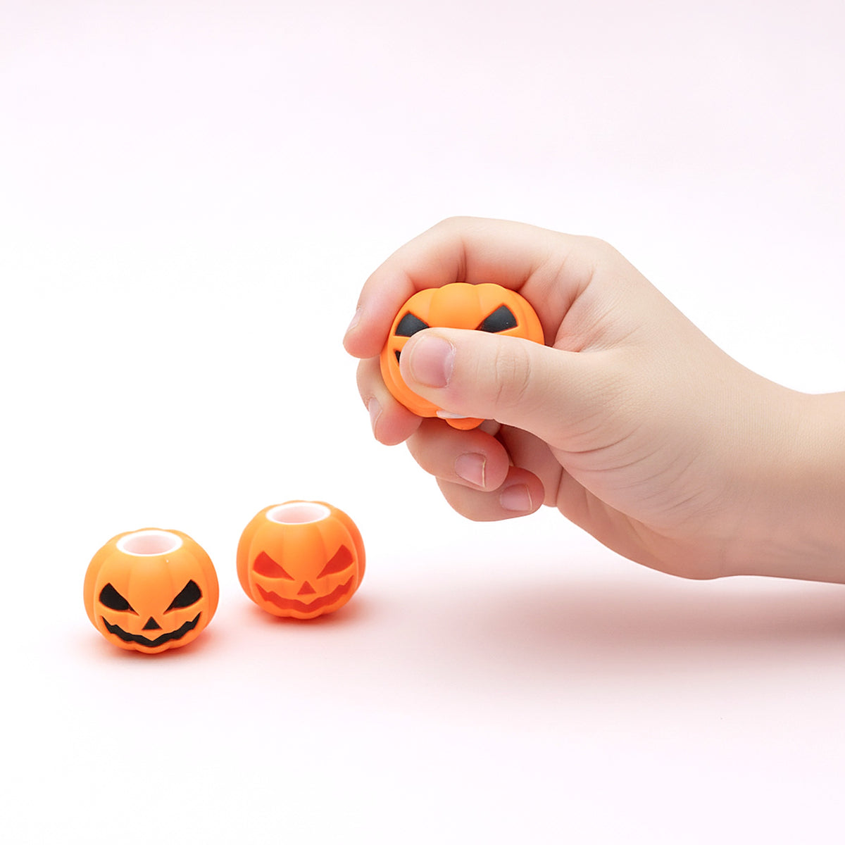 Squishy Citrouille souriante pressé dans une main d'enfant pour montrer sa taille
