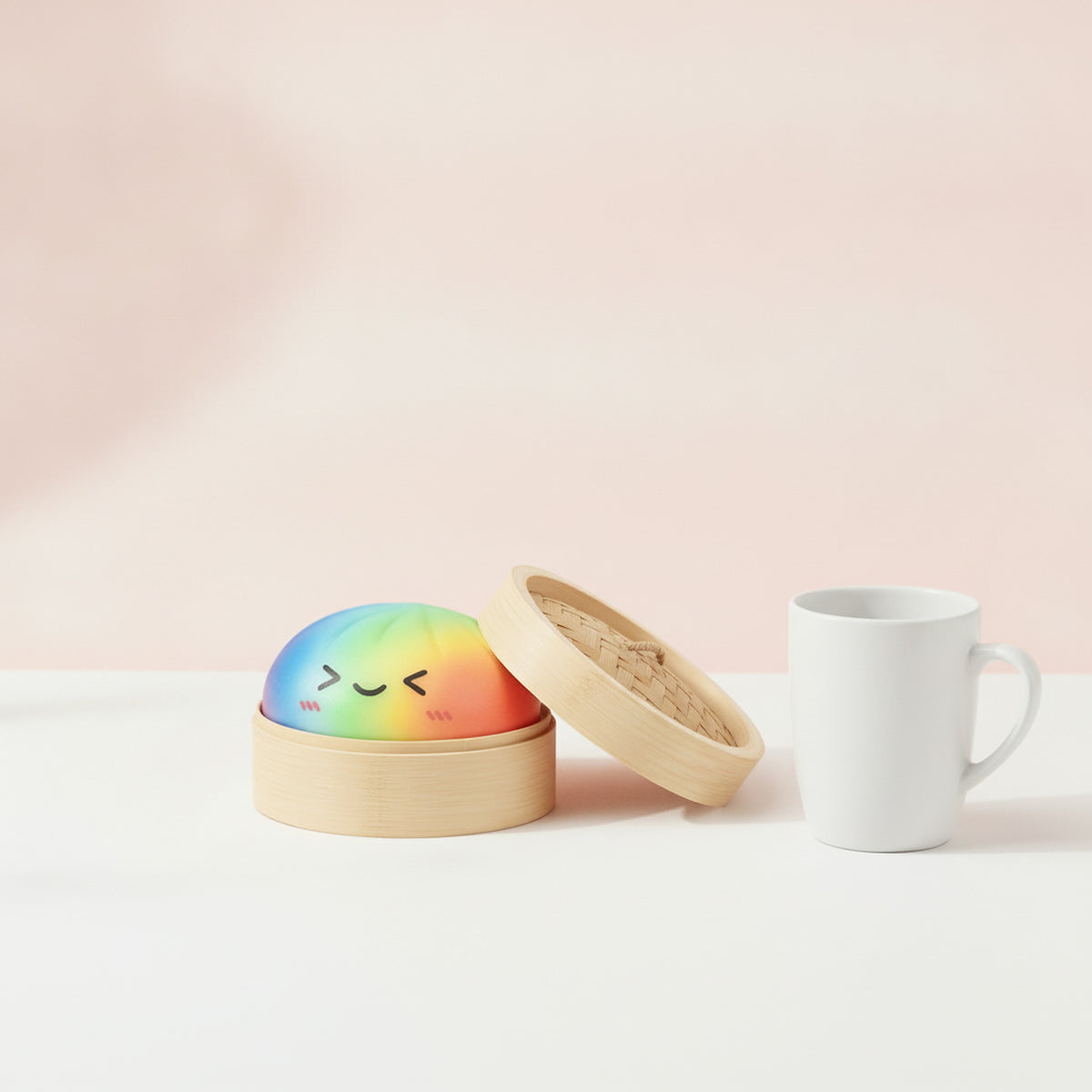Squishy géant ravioli dans son panier en bambou posé à côté d'une tasse pour montrer sa taille