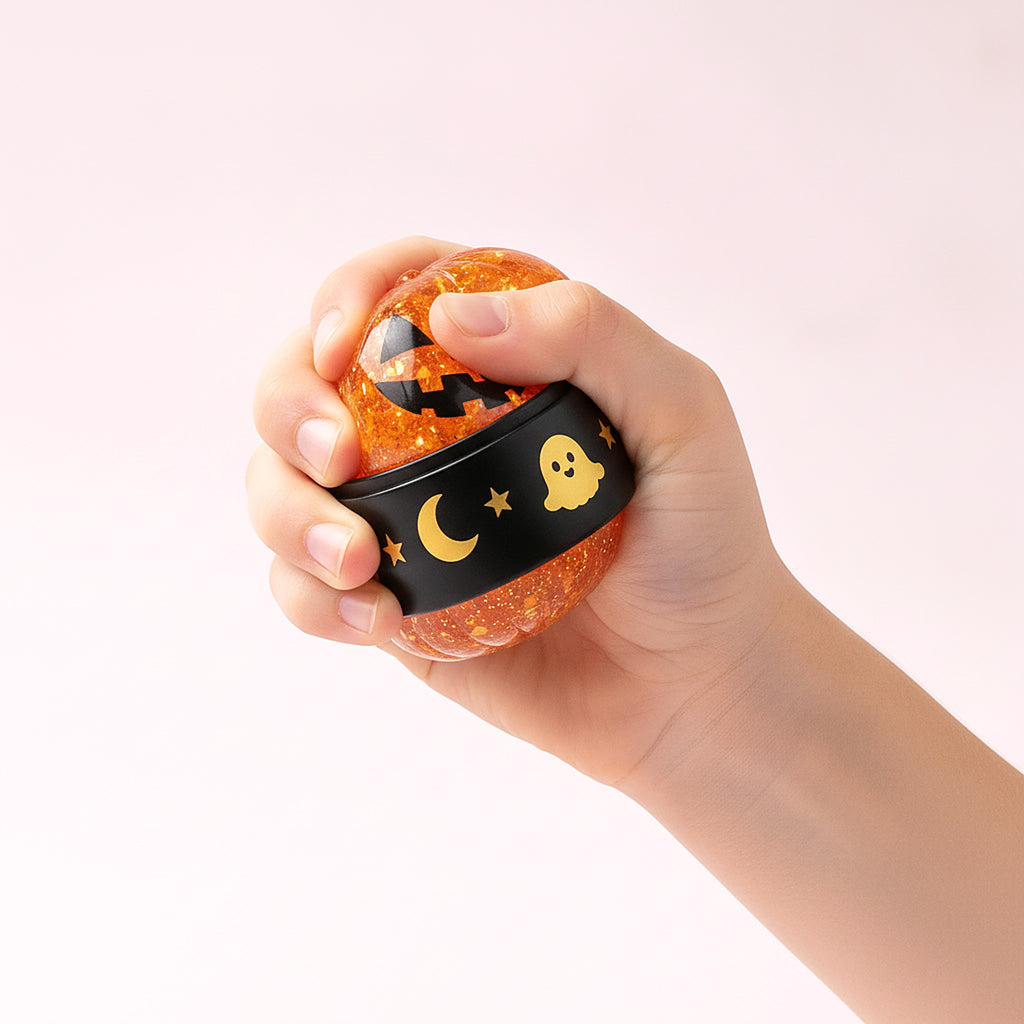 Squishy Ravioli Citrouille à paillettes dans une main d'enfant pour montrer sa taille