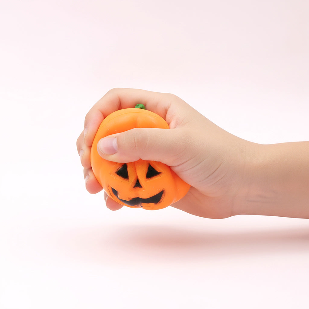 Squishy Tête de Citrouille pressé dans une main d'enfant pour montrer sa taille