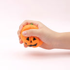 Squishy Tête de Citrouille pressé dans une main d'enfant pour montrer sa taille